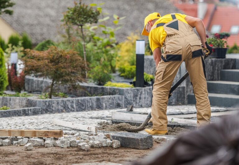 Installer setting stone and pavers for a hardscape project
