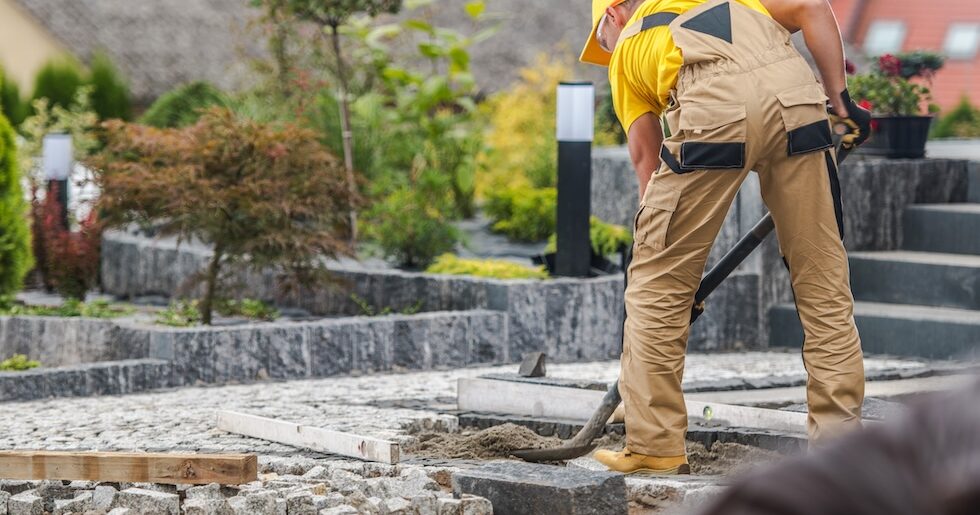 Installer setting stone and pavers for a hardscape project